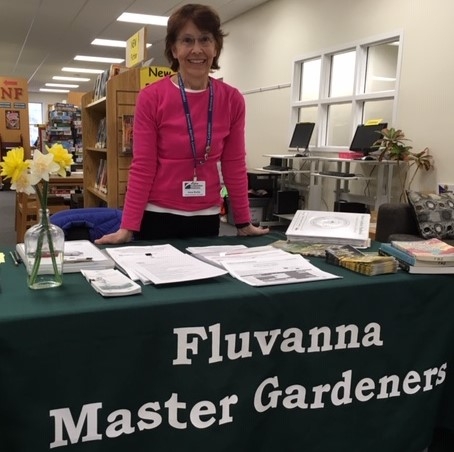 A Fluvanna Master Gardener standing at the help desk at the Fluvanna Library